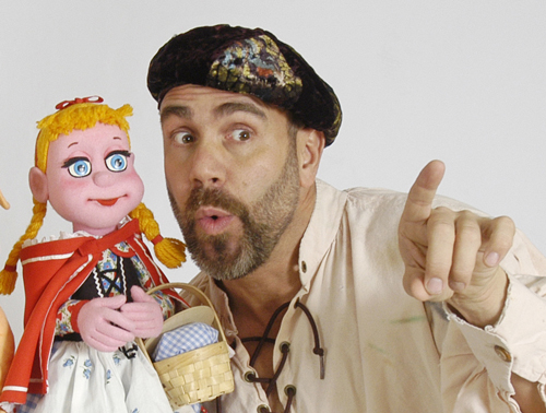 Lee Bryan in the Big Bad, Little Red, Pig Show, guiding a puppet by pointing into the distance.